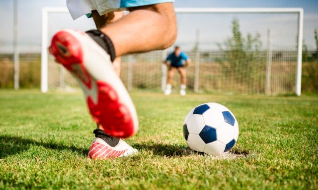 Soccer player kick the ball at the penalty