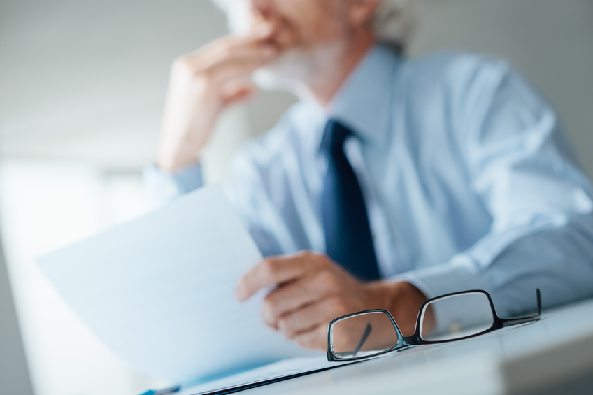 Pensive businessman reading a contract