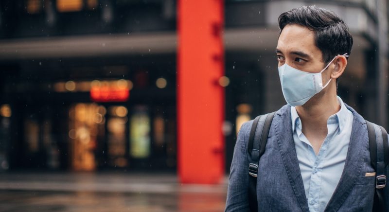Gentleman with in coronavirus infected city wearing a pollution mask