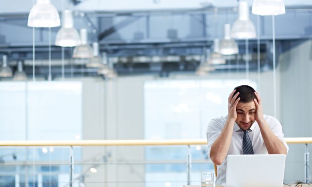 Manager looking at his laptop in despair